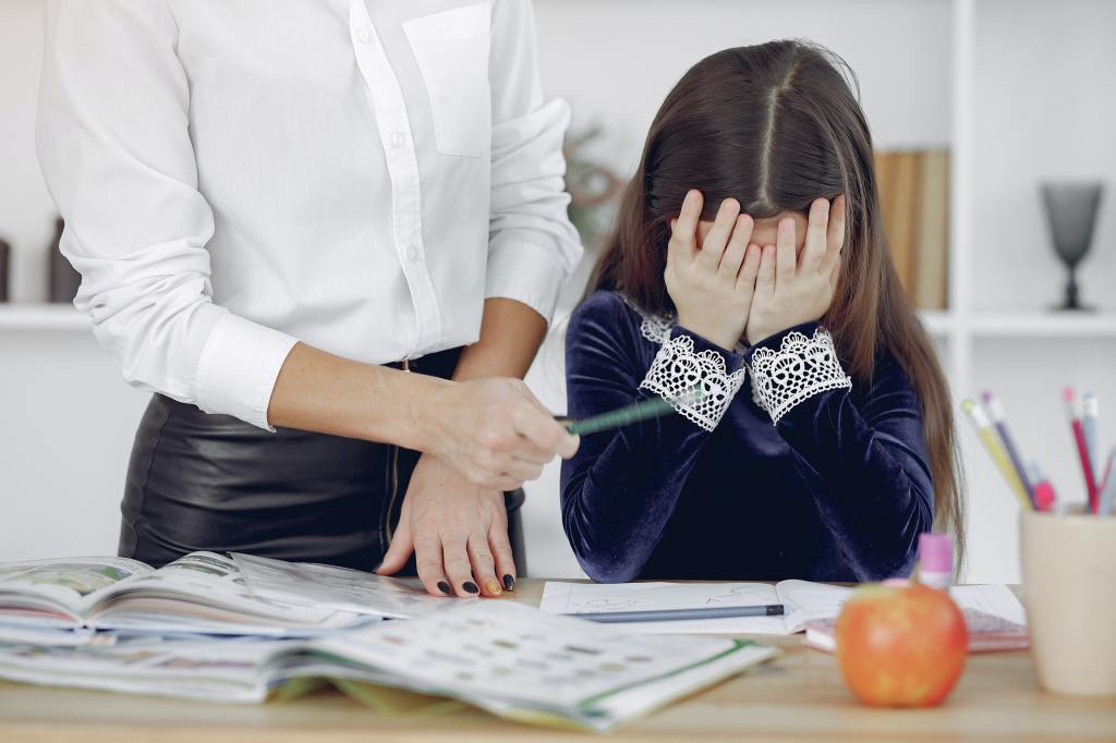 Image of a school child being reprimanded by a teacher